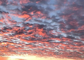 Morning sky over the Kansas City skyline, river in foreground.