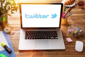 office workspace with laptop, Twitter logo on screen | #pitch wars #pitmad advice #pitmad pitches #pitmad tips #twitter pitch contests #Twitter pitch parties