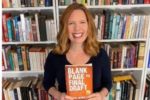 author Bryn Donovan holding a copy of her book BLANK PAGE TO FINAL DRAFT: HOW TO PLOT, WRITE, AND EDIT A NOVEL, STEP BY STEP.