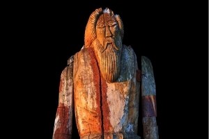 an old wooden statue of Odin with a long beard, looking a little bit like a Viking Santa Claus