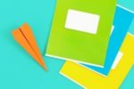 50 Essay Topics for Kids | image: notebooks and paper airplane