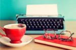 coffee mug, typewriter with paper, book, glasses