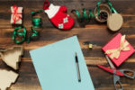 Christmas objects surrounding a note pad and pen