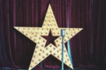 a star on a stage next to a microphone