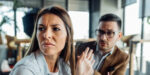 angry man and woman in cafe: she turns away, frowning, holding up a hand