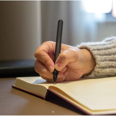 hand with a pen writing in a book - how to fight fascism post