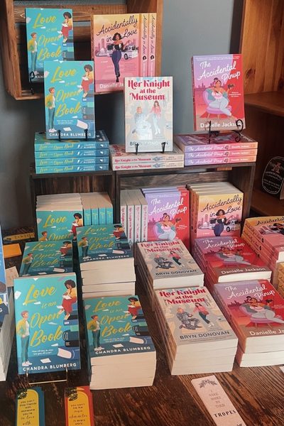 romance book display, including Love is an Open Book, Her Knight at the Museum, and The Accidental Pinup