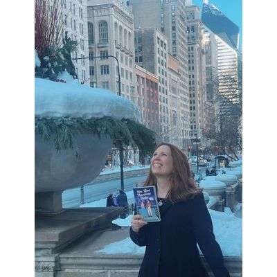 Author Bryn Donovan holding her book Her Time Traveling Duke and looking up at the sky