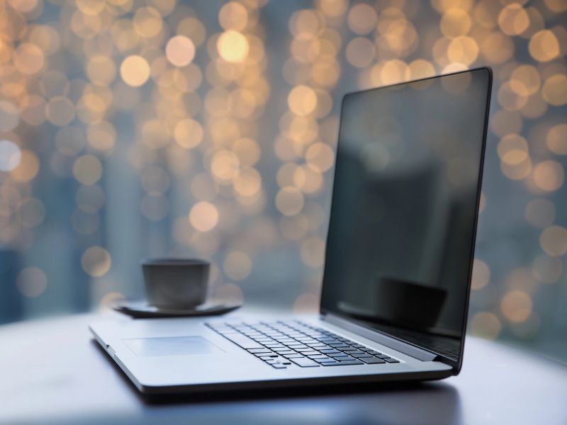 laptop, coffee, twinkly lights in background