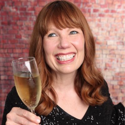 author Bryn Donovan wearing sequins and holding a glass of champagne