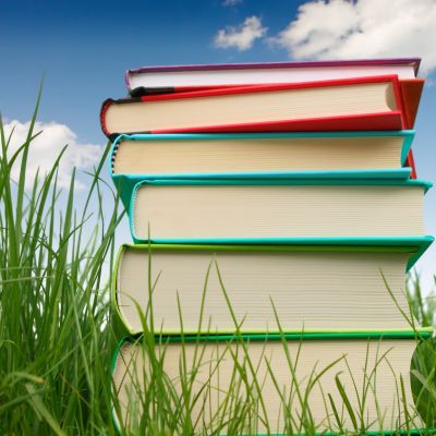 stack of books, grass, summer sky