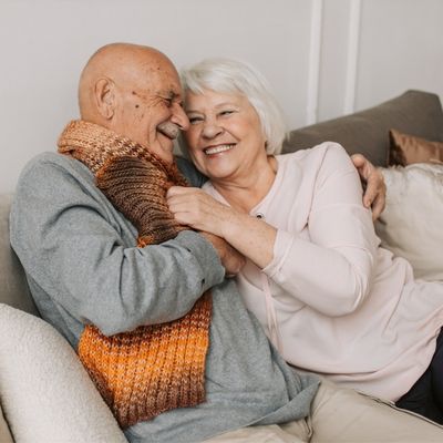older couple snuggling and flirting on the sofa - writing old people
