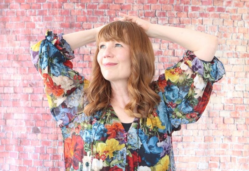 Author Bryn Donovan wearing floral blouse looking up